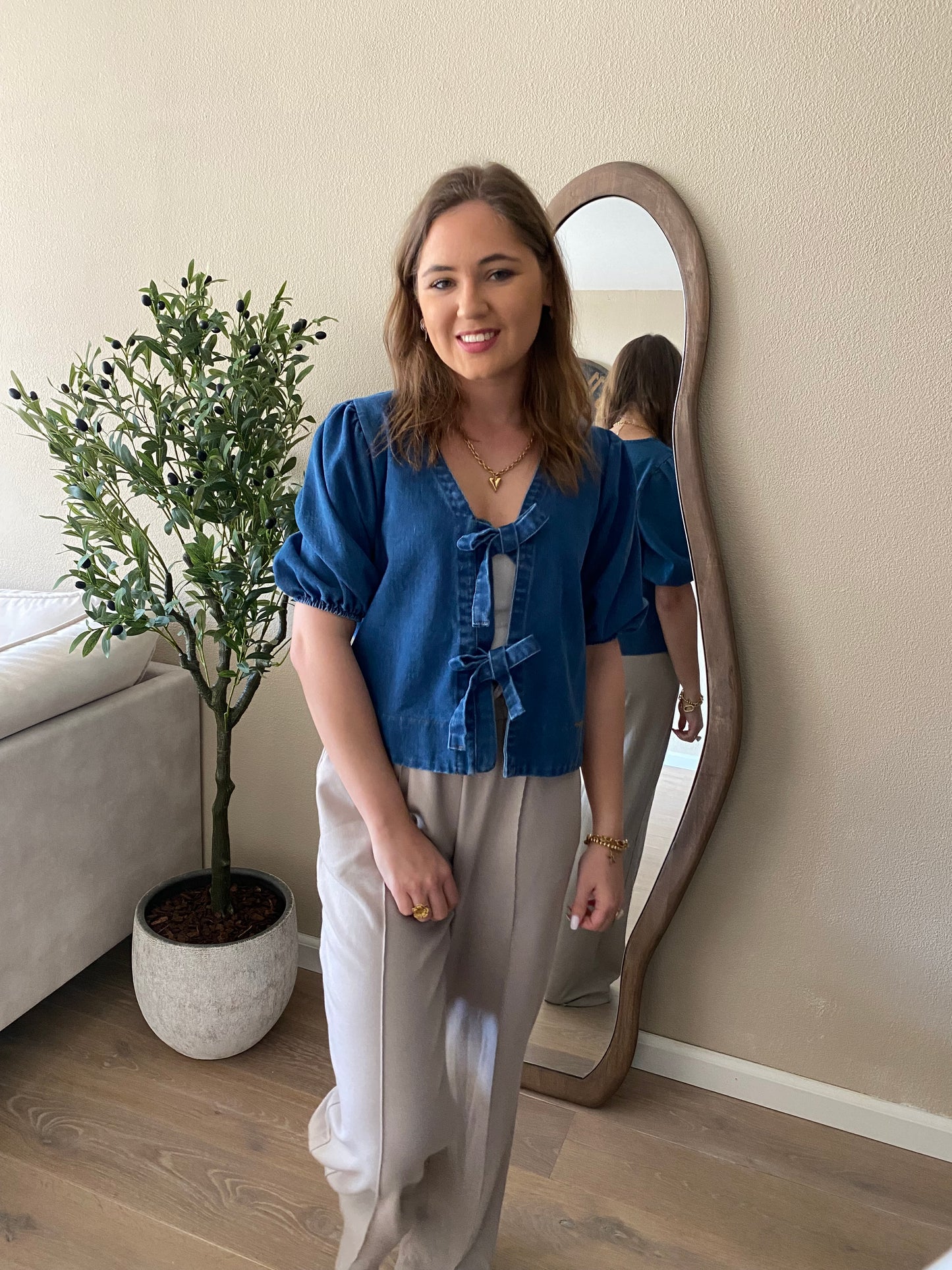 Zachte donkerblauwe denim stof met decoratieve strikjes – trendy voorjaarsitem.