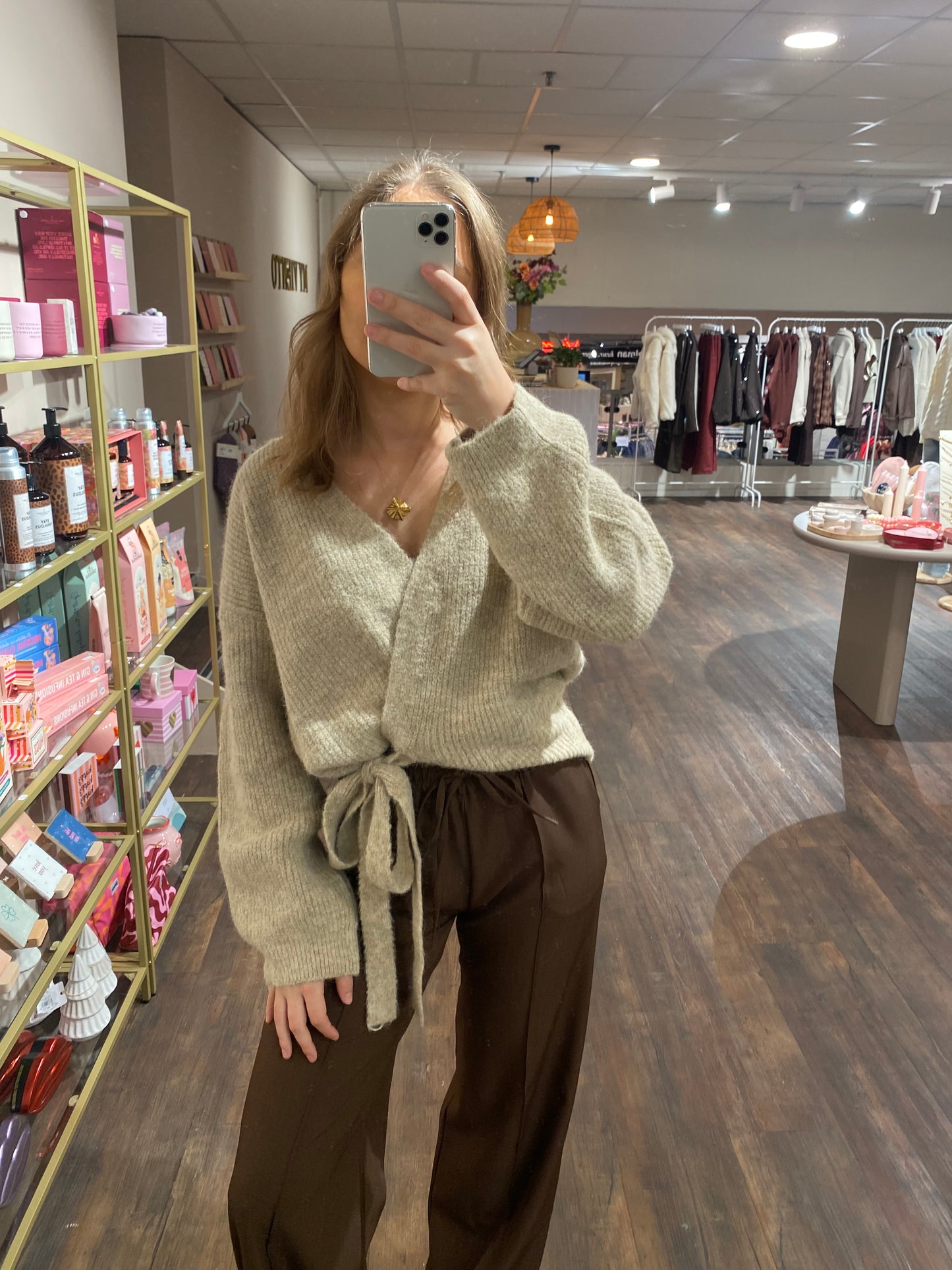 Zacht beige vest met strikdetail, elegant en comfortabel.