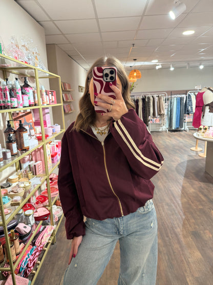 Bordeaux jasje met sportieve strepen en gouden details.  