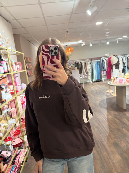 Bruine dames sweater met opdruk die doorloopt op de mouwen.  