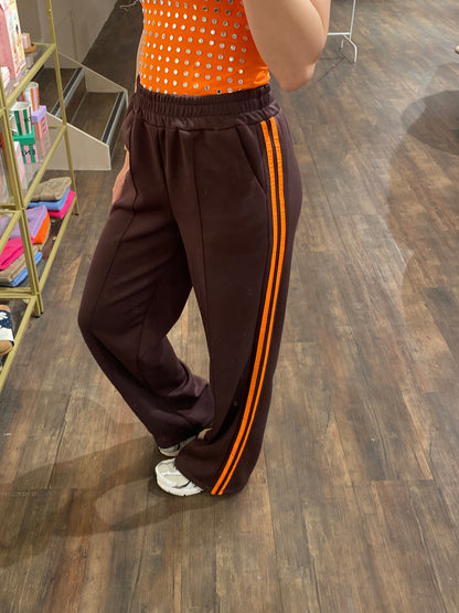 Bruine pantalon met opvallende oranje strepen.