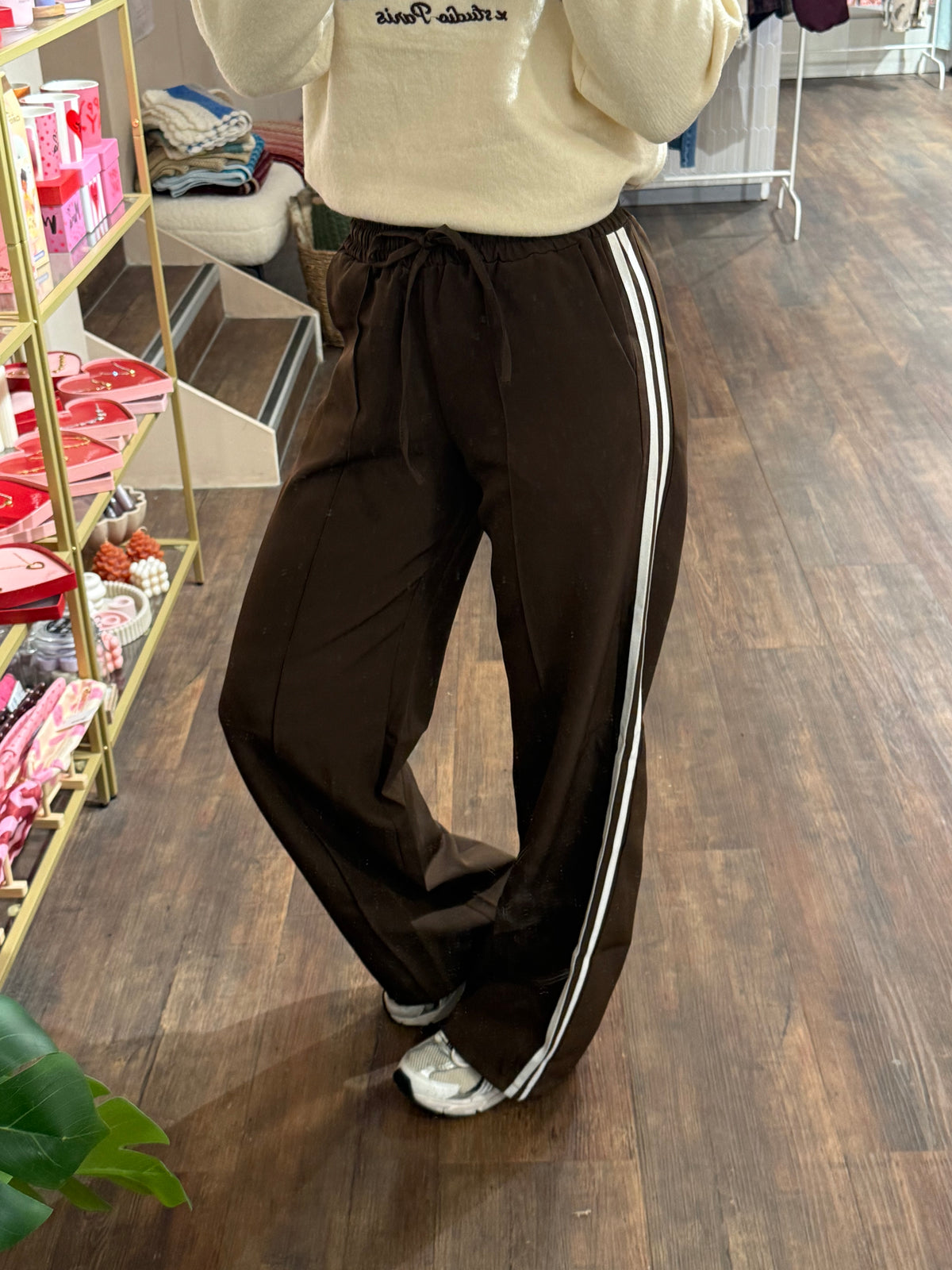 Bruine pantalon met twee witte strepen aan de zijkant.  