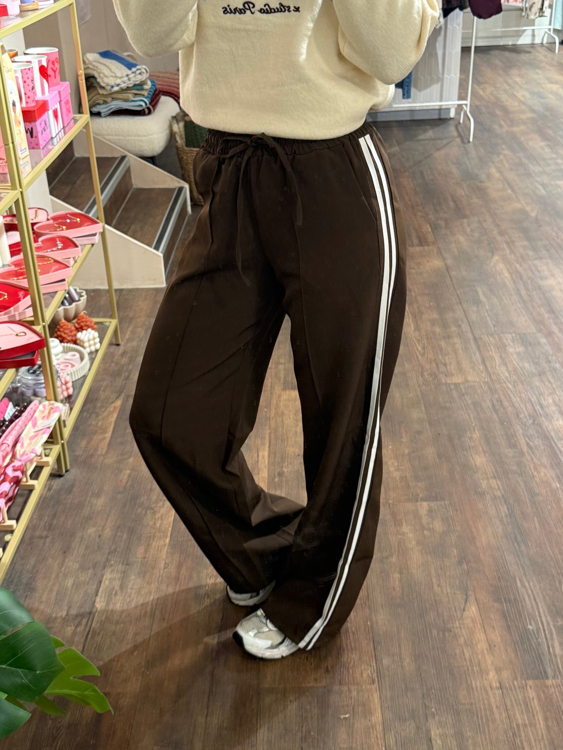 Bruine pantalon met twee witte strepen aan de zijkant.  