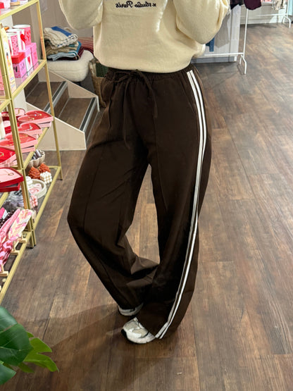 Bruine pantalon met twee witte strepen aan de zijkant.  