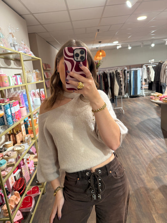 Creme trui met cut out detail bij de hals. 