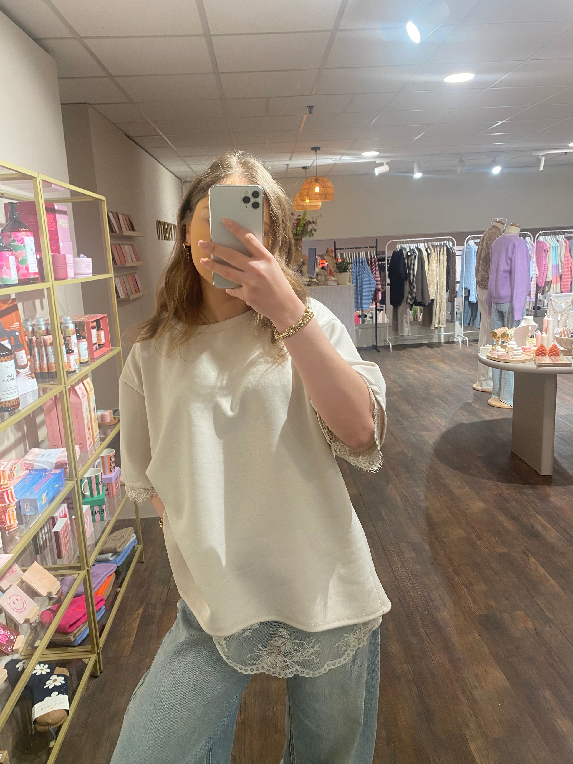 Oversized beige top met vrouwelijke kanten accenten.