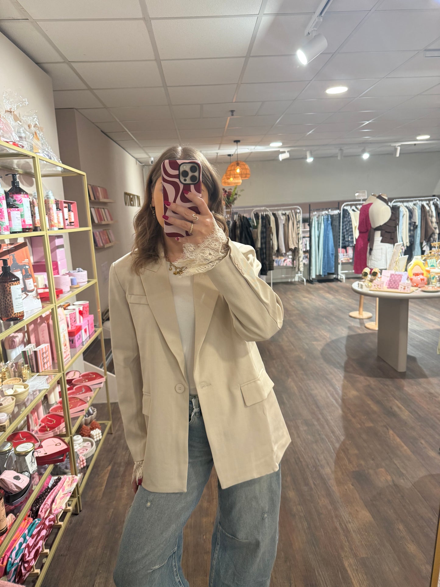 Dames blazer in crème met vrouwelijke kanten details.  