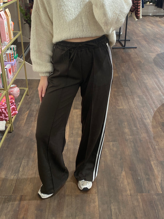 Donkerbruine dames broek met twee witte strepen aan de zijkant.