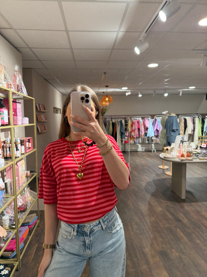 Gestreept shirt in rood en roze kleuren.