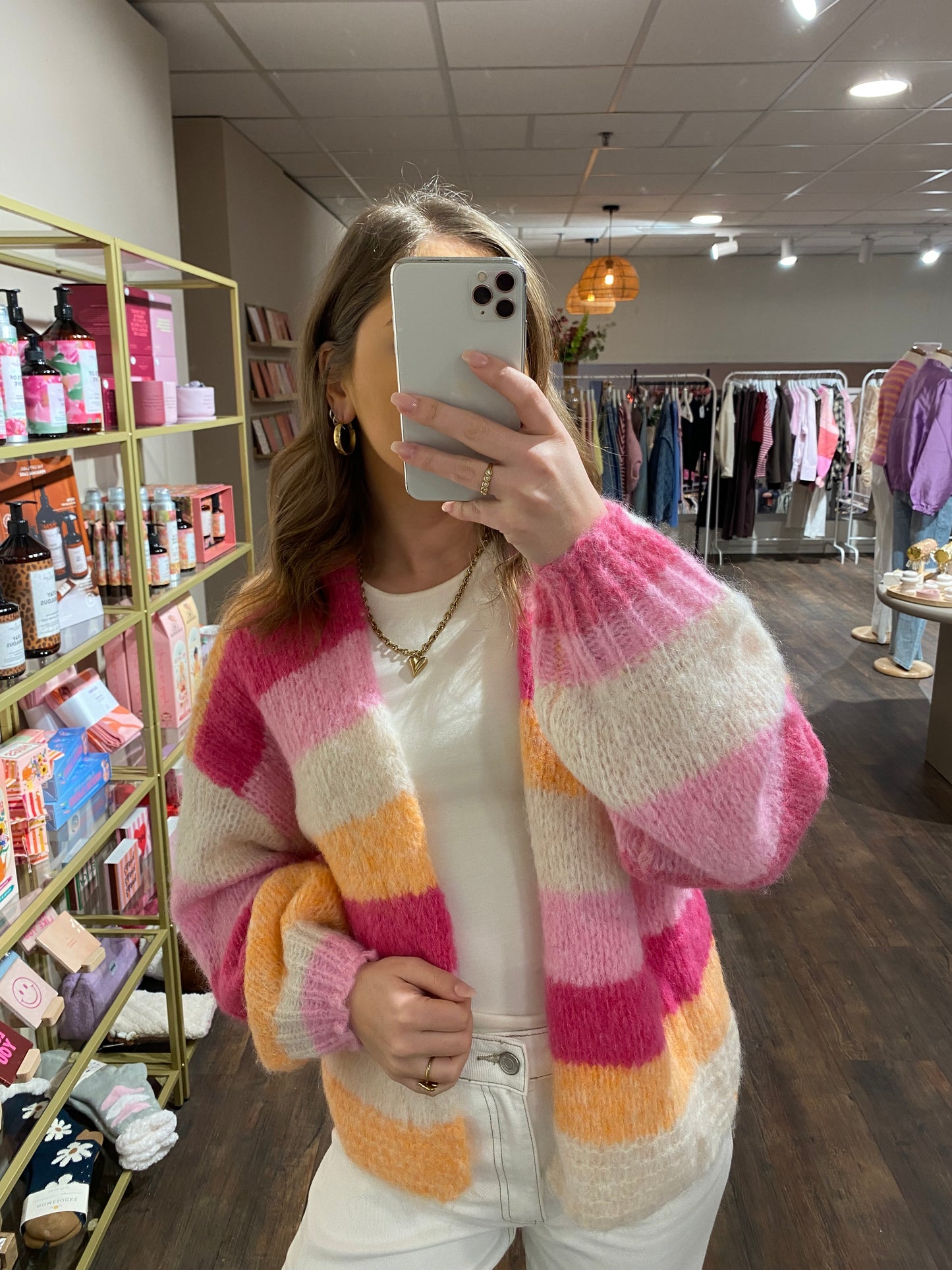 Cardigan met oranje, roze en beige strepen.