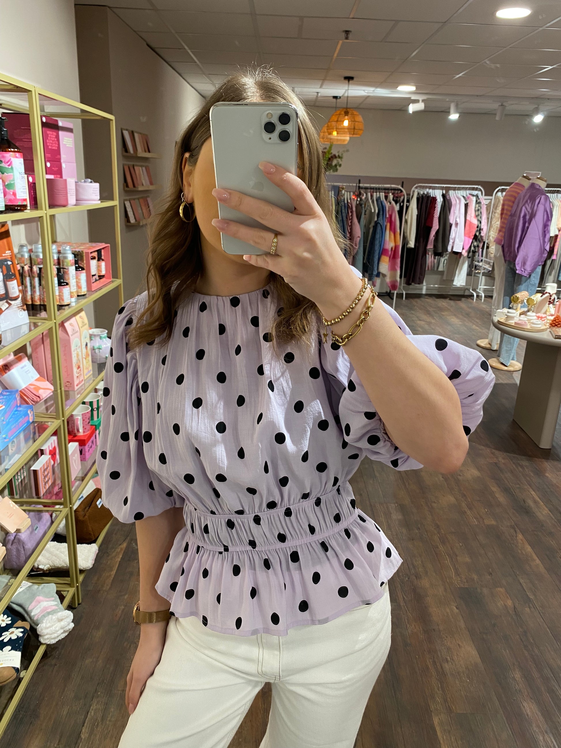 Getailleerd lila topje met zwarte stippen.