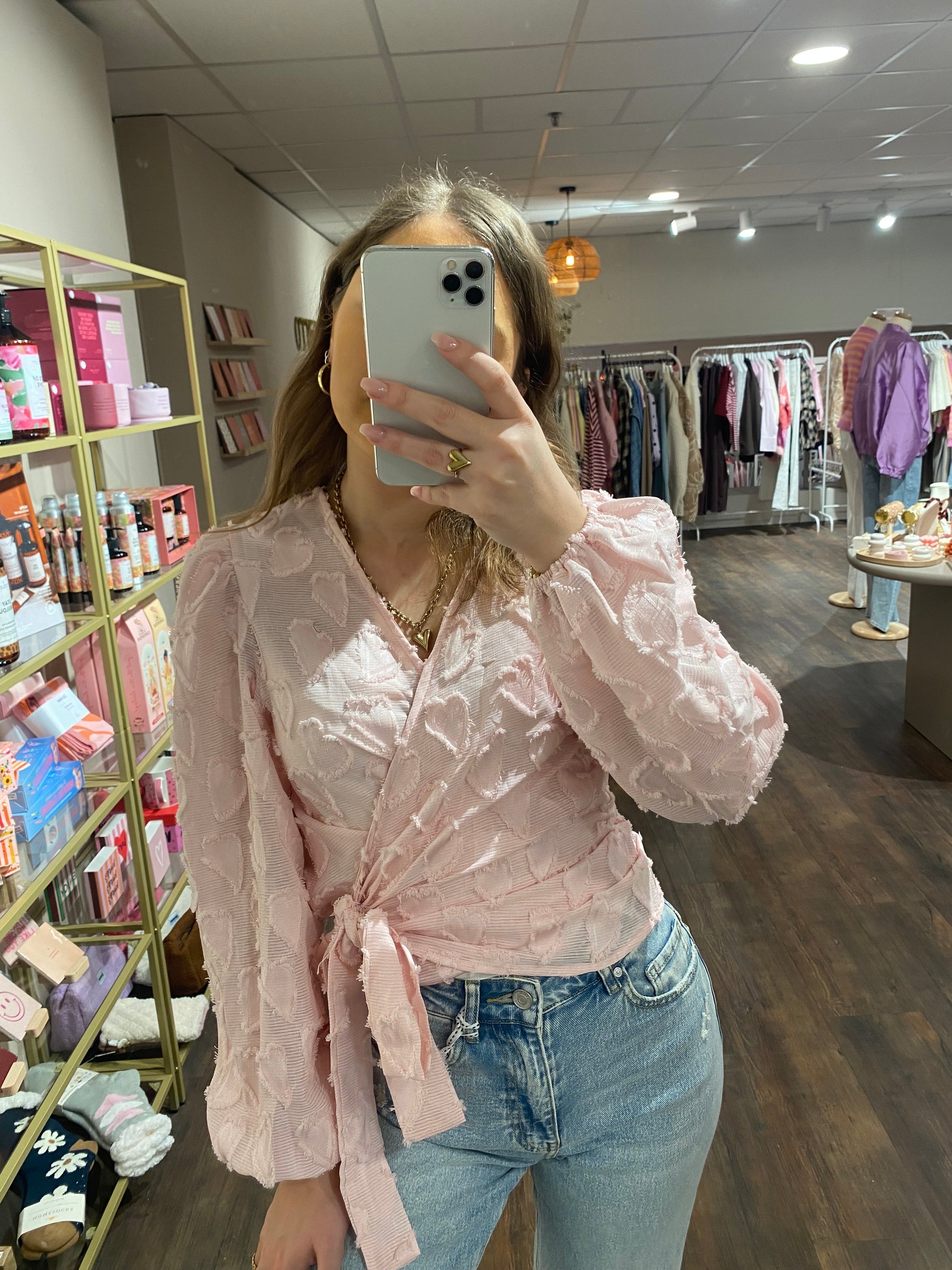 Lichtroze overslag blouse met hartjespatroon.