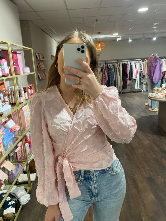 Lichtroze overslag blouse met hartjespatroon.