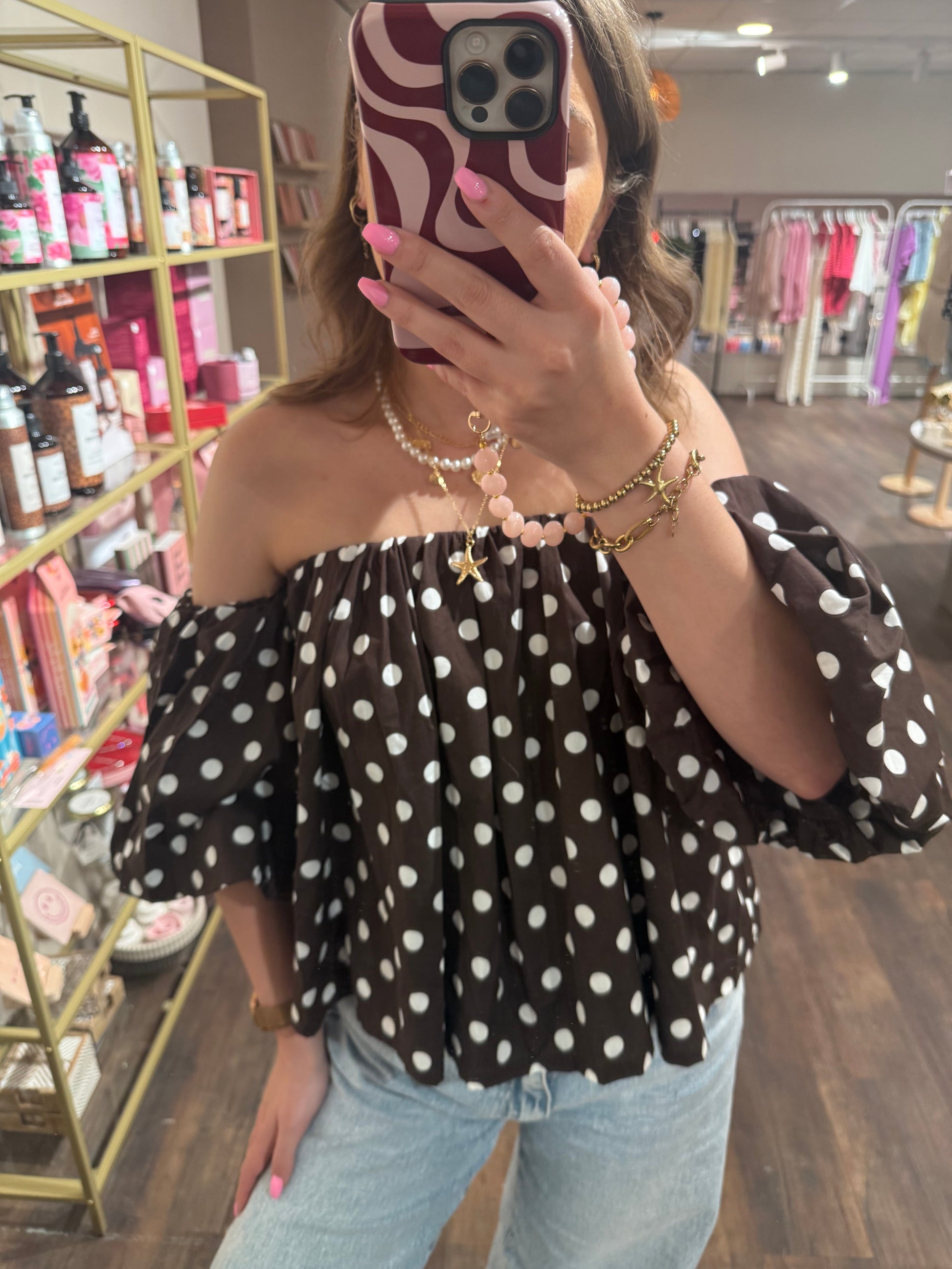 Trendy dames top met stippen en blote schouders.