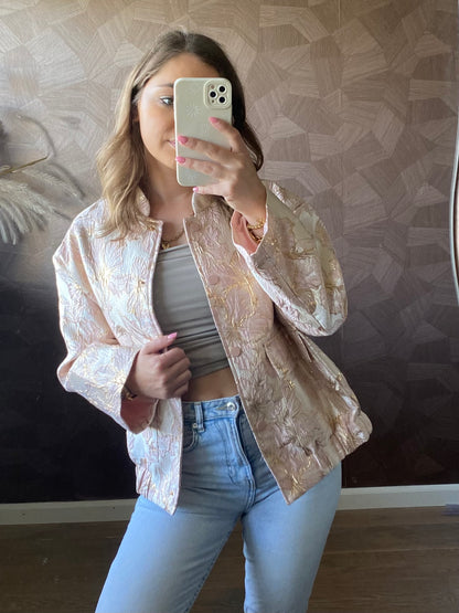Steekzakken en drukknoopjes op roze jacquard bomber – functioneel én chic.