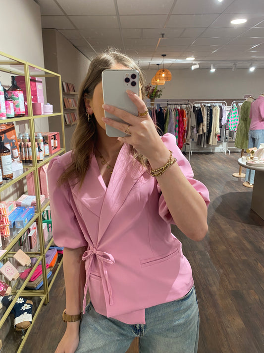 Roze wikkelblazer met strikdetail.