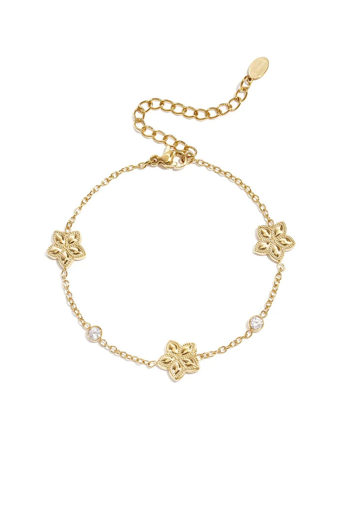 Wisselend patroon van bloemen en steentjes armband goud