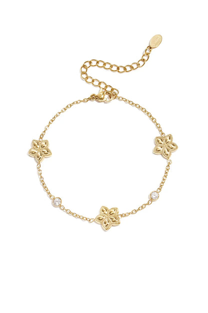 Wisselend patroon van bloemen en steentjes armband goud