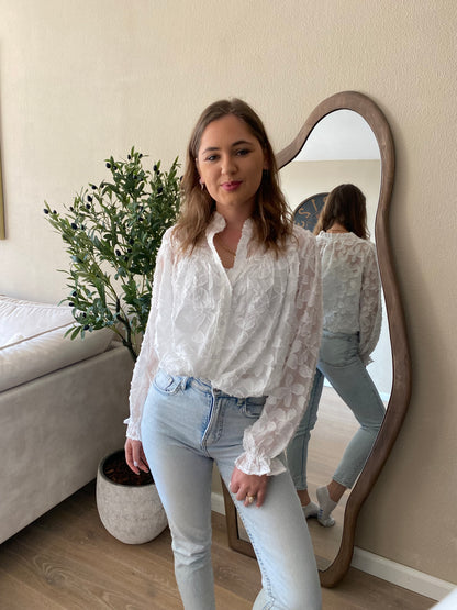 Witte blouse met 3D bloemenstructuur en lange mouwen – lente musthave