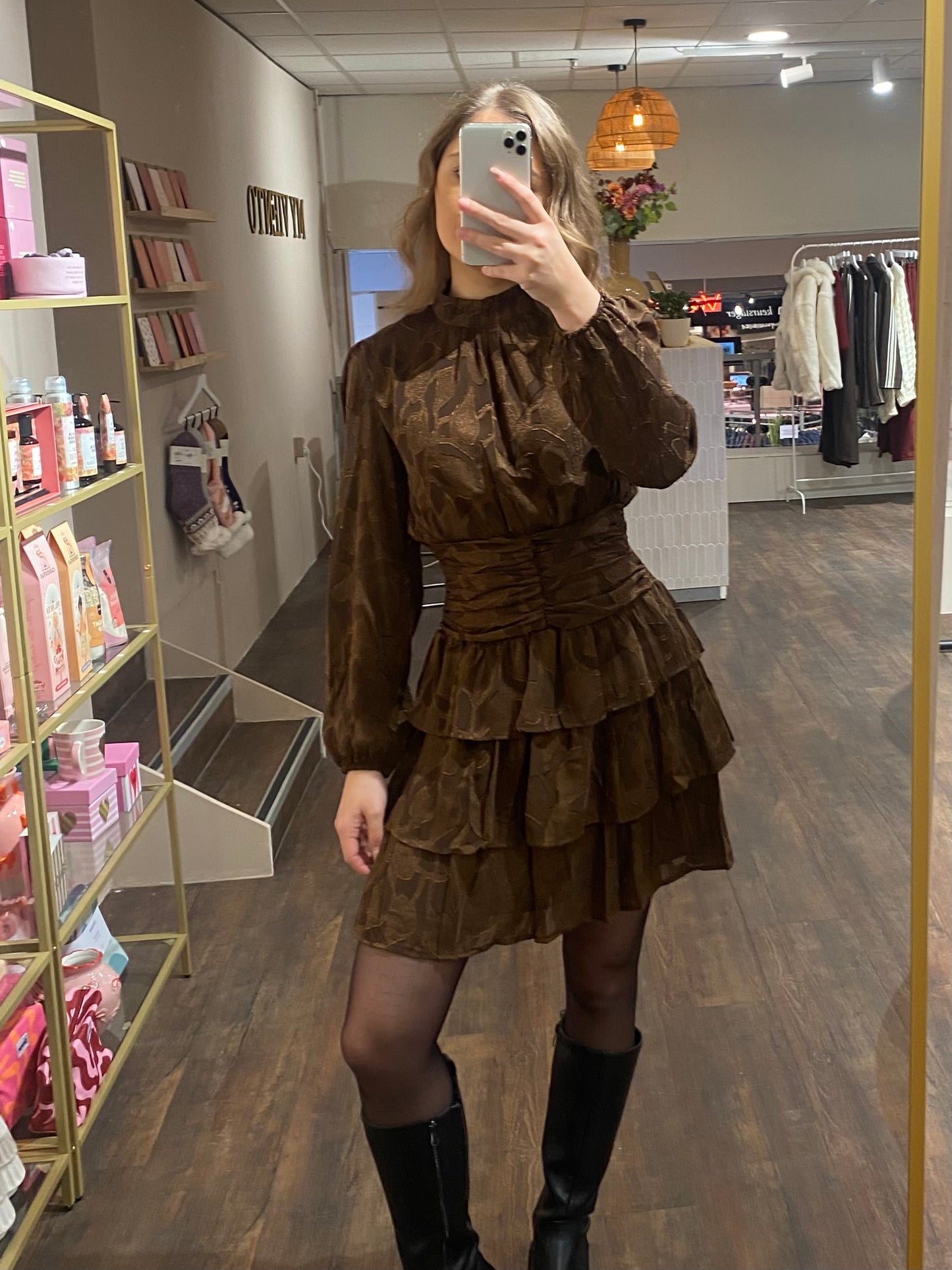 Bruin jurkje met ruffles, hoge hals en tailleband voor een flatterende pasvorm.