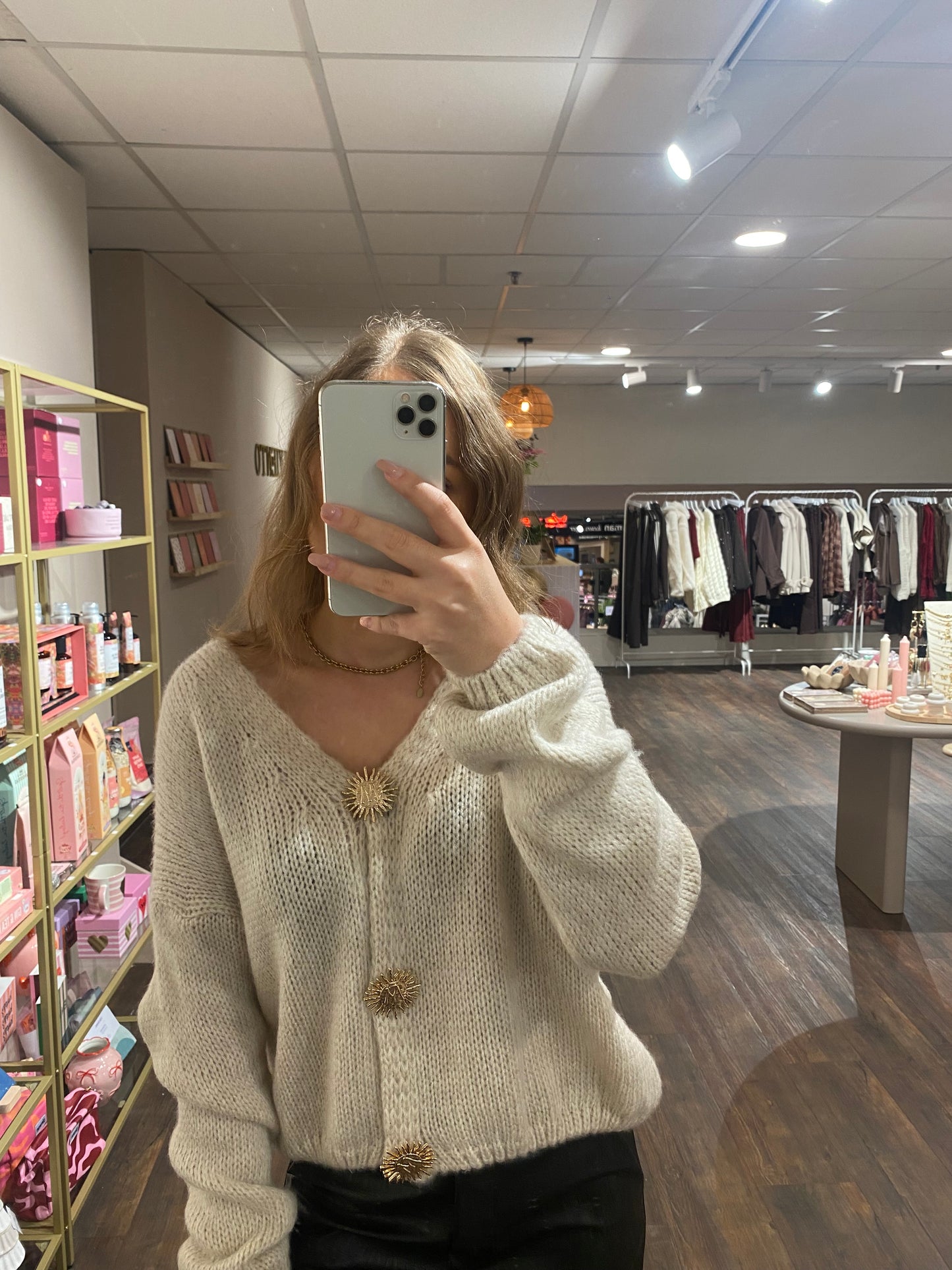 Crème knit met lange mouwen en gouden zonnetjes knopen, comfy en stijlvol.