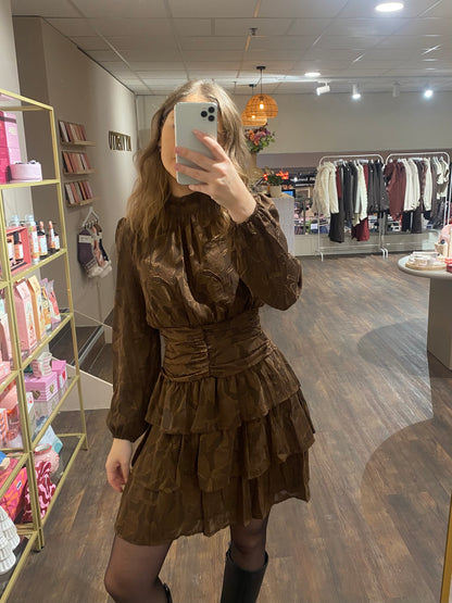 Damesjurk met reliëfpatroon en speelse ruches, elegant en vrouwelijk.