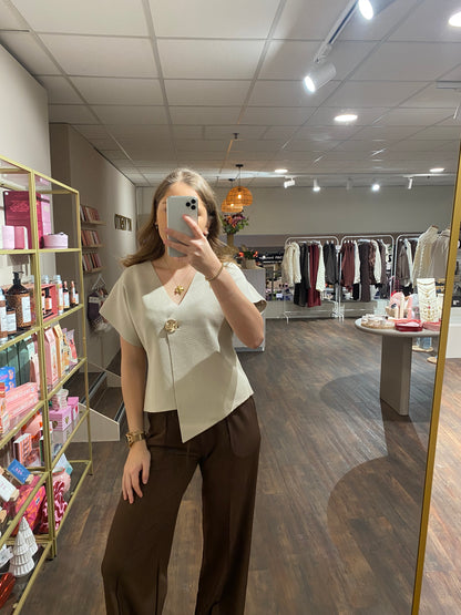 Dames top met korte mouwen en gouden knop, chic en vrouwelijk.