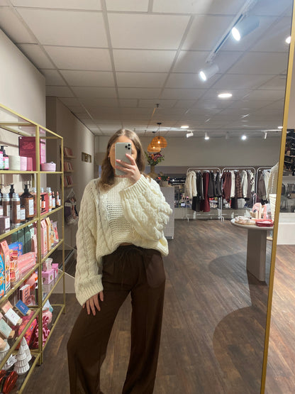 Witte gebreide trui met wijde mouwen en kabelstructuur, tijdloos en trendy.