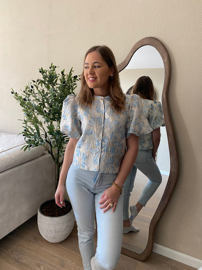 Lichtblauwe jacquard top met vrouwelijke snit – opvallend en elegant.