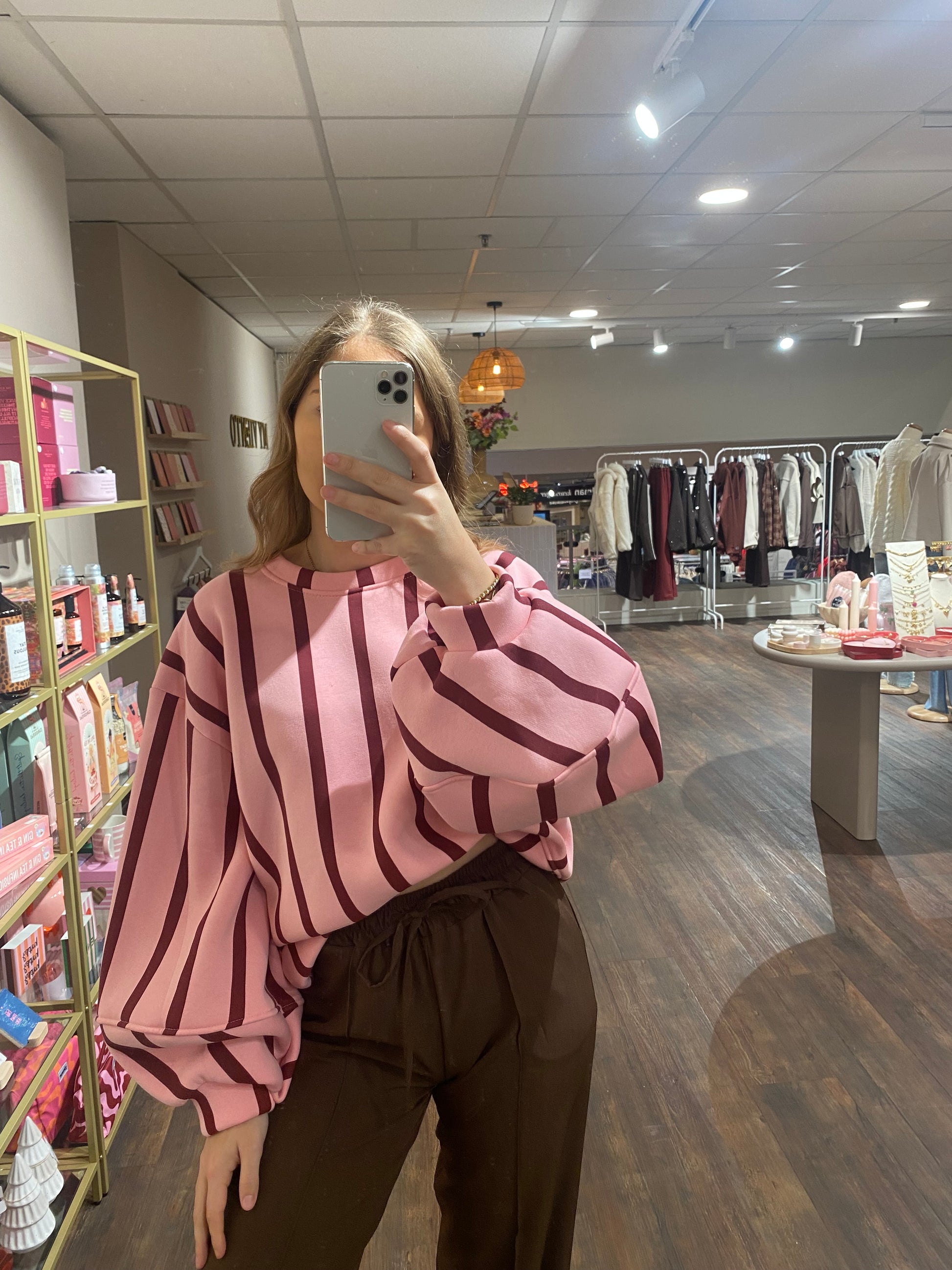 Roze sweater met bordeauxrode strepen, zachte binnenkant en ballonmouwen.