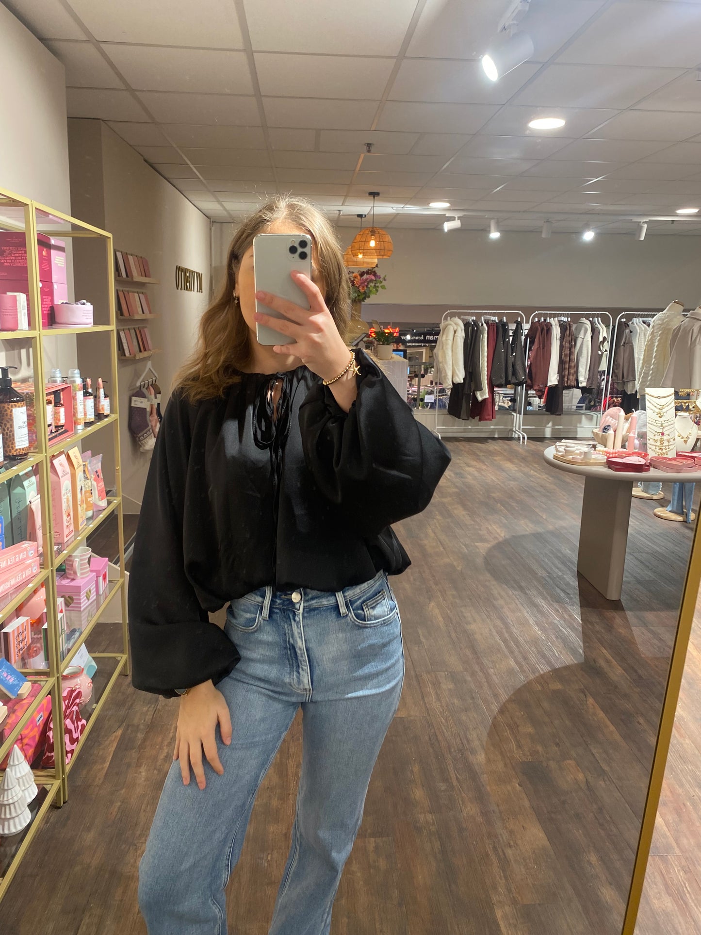 Glanzende zwarte blouse met vrouwelijke details en speelse afwerking.